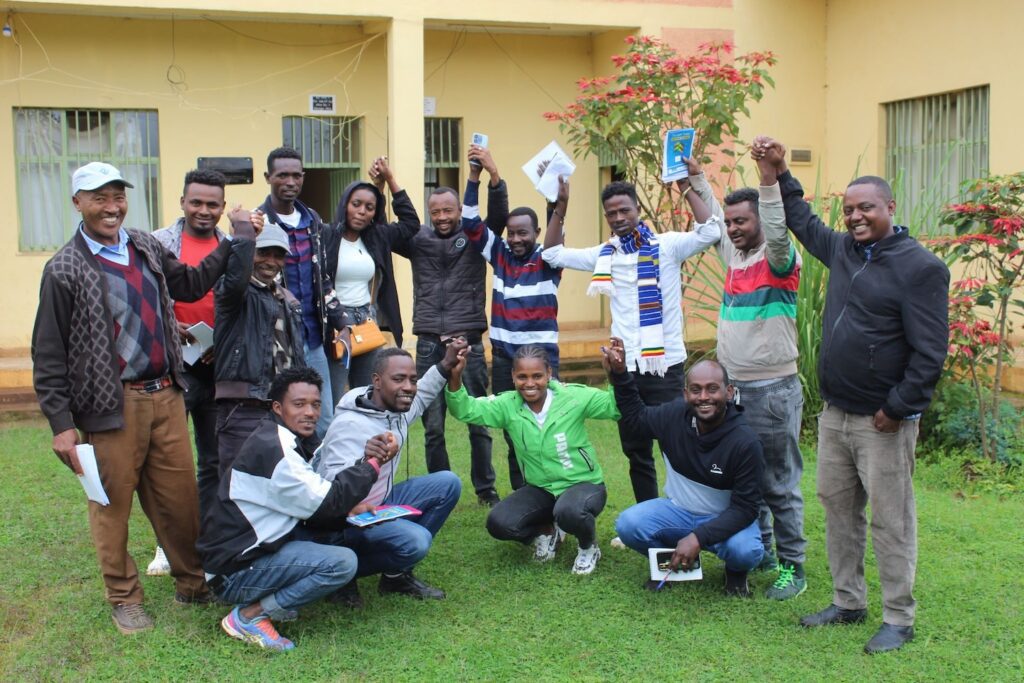 group of people standing and sitting together outside a building, cheering together
